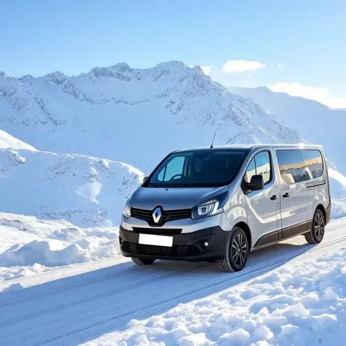 taxi station de ski alpes Véhicule Renault dans un paysage montagneux dans les Alpes enneigé sous un ciel bleu.