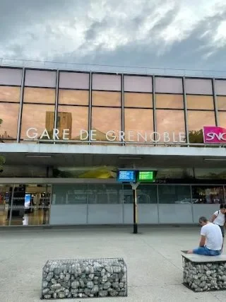 Gare de Brétigny, bâtiment moderne avec vitrages, bancs et panneaux d'affichage.