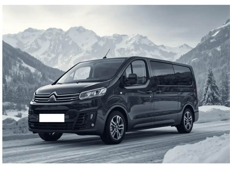 taxi van station de ski Van noir garé sur une route de montagne enneigée.