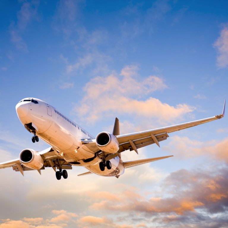 Avion en approche sous un ciel coloré au crépuscule.