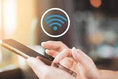 Main dans une position de saisie sur un smartphone avec un symbole de Wi-Fi en arrière-plan.